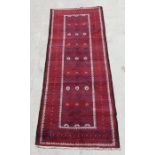 A Persian Balouch hand knotted woollen runner with repeat medallions within geometric borders, 275