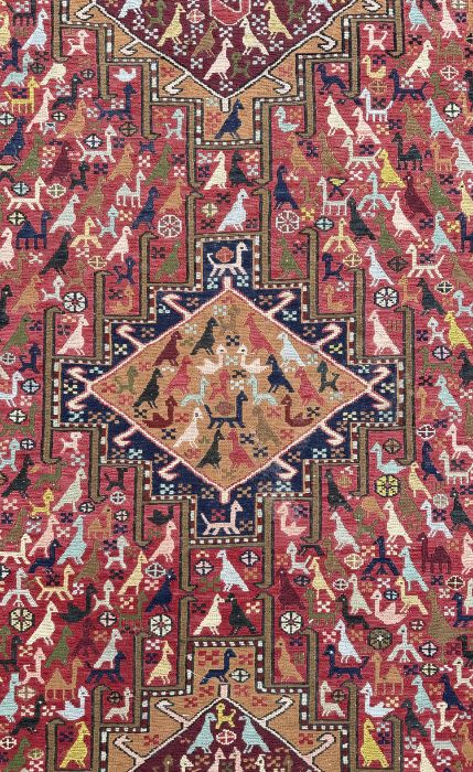A Persian flatweave rug decorated with a multitude of stylised animals within a geometric border, on - Image 2 of 4