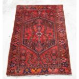 A Persian Shiraz woollen hand knotted rug with central medallion and stylised floral decoration,