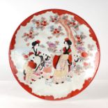 A late 19th century Japanese Kutani charger decorated with figures in a landscape, red character
