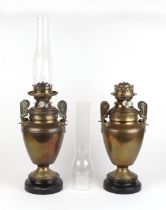 A pair of Victorian brass oil lamps, 40cms high excluding flues. Condition Report One flue