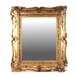 A Victorian carved wood and gesso gilt wall mirror with rectangular plate, 64cms wide.