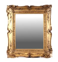 A Victorian carved wood and gesso gilt wall mirror with rectangular plate, 64cms wide.