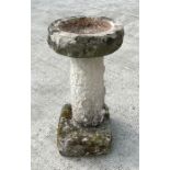 A well weathered stone bird bath with circular bath, on a column with square base, 38cms diameter.