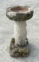 A well weathered stone bird bath with circular bath, on a column with square base, 38cms diameter.