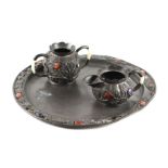 A Chinese pewter sugar bowl and milk jug on matching circular tray, with applied cabochon