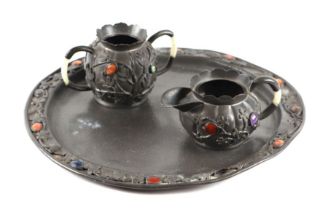 A Chinese pewter sugar bowl and milk jug on matching circular tray, with applied cabochon