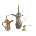 A large Turkish / Islamic brass dallah coffee pot, 45cms high; together with a similar smaller,