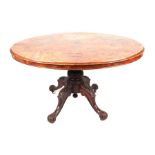 A Victorian walnut loo table with an oval tilt-top on a carved quatreform base, 130cms wide.