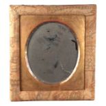 A Liberty style wall mirror with fabric covered frame and oval bevel edged plate, 46cms wide.