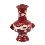 A Chinese vase decorated with dragons on a red ground, six character blue mark to the underside,