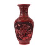 A Chinese cinnabar vase, the panels decorated with prunus and chrysanthemums, 32cms high, boxed.