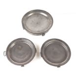 Three early 19th century pewter hot plates, each engraved with an armorial, 26cms diameter (3).