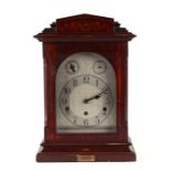 An Edwardian mantle clock, the silvered dial with Arabic numerals and German movement, in an