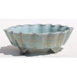 A Chinese pale celadon glaze oval footed planter with wavy rim, gilt decoration and calligraphy,