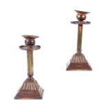 A pair of Arts & Crafts style copper and brass candlesticks with stepped square bases, 17cms high.