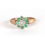 A 9ct gold cluster ring set with a single central diamond surrounded by pale green stones, approx UK