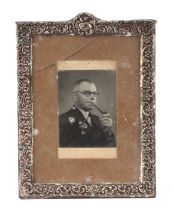 A silver rectangular strut photo frame with scroll decoration, marks indistinct, 19cms wide.