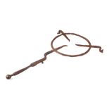 A large 17th / 18th century wrought iron hearth trivet with brass ball handle, 68cms overall