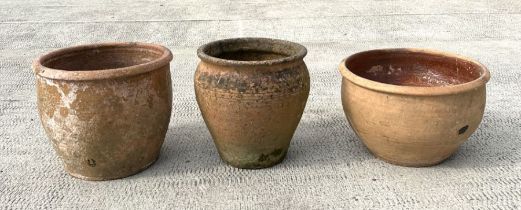 Three large terracotta pickling pots or planters, the largest 33cms high (3).