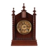 A late 19th century American oak cased mantle clock, the white paper dial with Roman numerals, 40cms