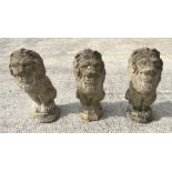 A group of three well weathered stone figures of seated lions, each 44cms high (3).