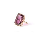 A yellow metal dress ring set with a large amethyst coloured stone, Approx UK size Q. 12.5g