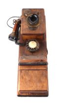 A wall mounted Western Electric type telephone with spin dial, separate hand and ear piece, 58cms