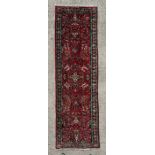 A Persian hand knotted runner with stylised floral design, on a beige ground, 280 by 78cms (61/19).