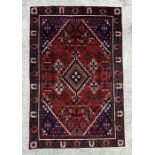A Persian Shiraz hand knotted woollen rug with central diamond gul within a floral border, on a
