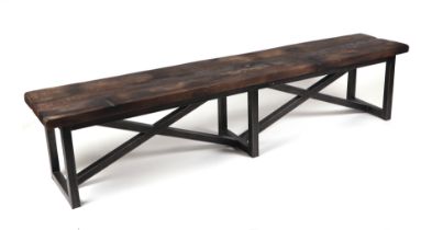 A Timothy Oulton Axel bench with double 'X' frame supports, made from reclaimed wood from