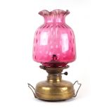 A Victorian glass oil lamp with cranberry glass shade, approx 47cms high. Condition Report The shade