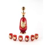 A Murano ruby glass liquor set comprising decanter and six glasses with enamelled floral