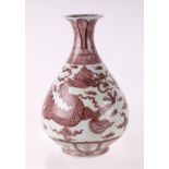 A Chinese red and white baluster vase decorated with a dragon amongst clouds, 31cms high.