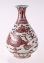 A Chinese red and white baluster vase decorated with a dragon amongst clouds, 31cms high.