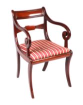 A mahogany desk chair with scroll arms, sabre front supports and drop-in upholstered seats.