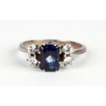 An 18ct white gold ring set with a large square pale blue sapphire and flanked by four white stones,