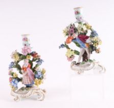 A pair of Meissen style figural porcelain chambersticks with applied figures of a man drinking ale