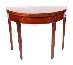 A mahogany demi lune tea table on square tapering legs terminating in spade feet, 94cms wide.