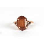 A 9ct gold dress ring set with a large oval amber coloured stone, approx UK size O, 2.7g.