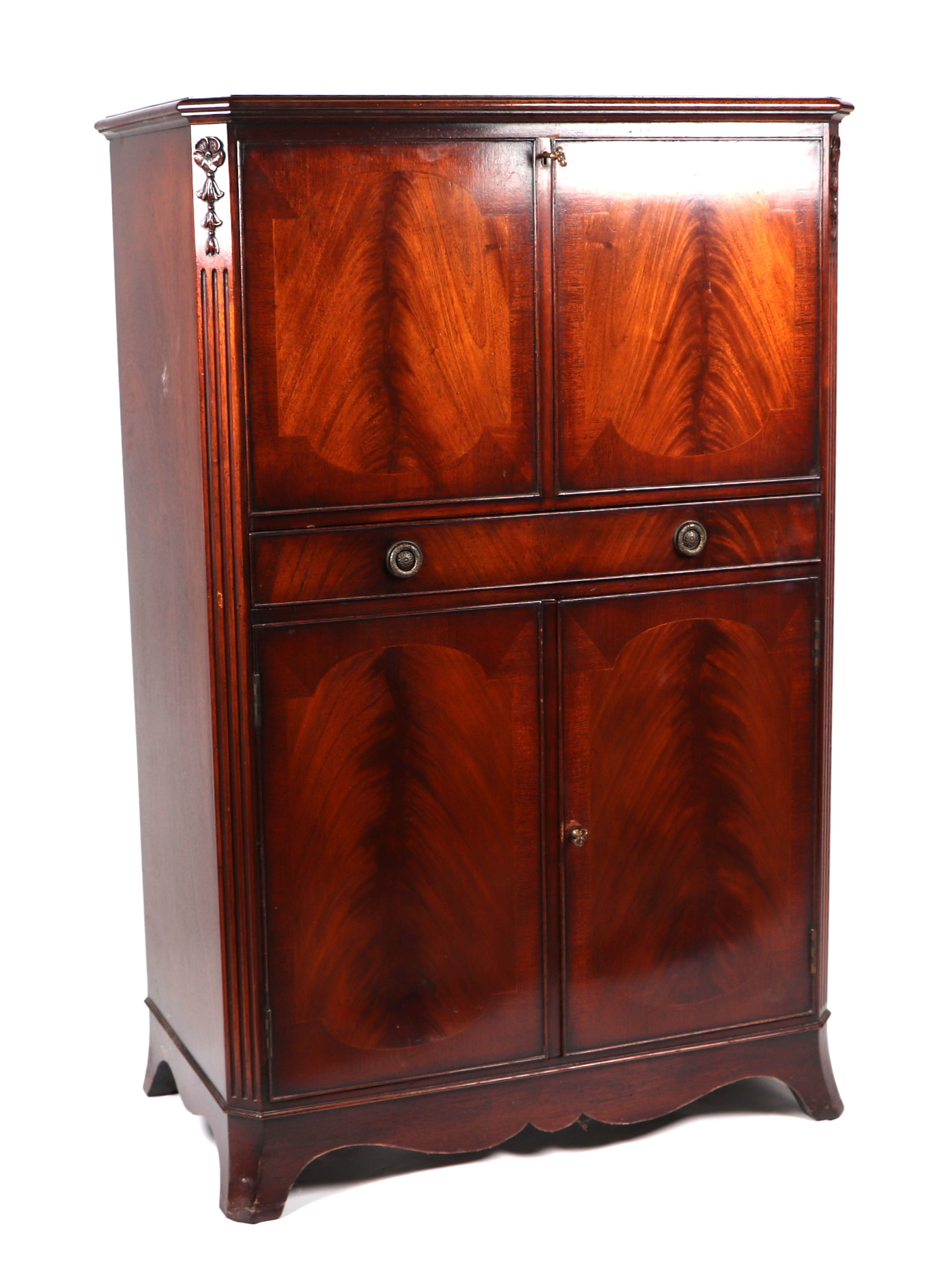 A reproduction figured mahogany drinks cabinet, the fall-flap enclosing a mirrored interior above