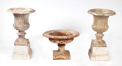 A pair of well weathered composite Campana urns on stands, 28cms diameter; together with another