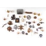 A quantity of military badges, sweetheart brooches, lapel badges and buttons