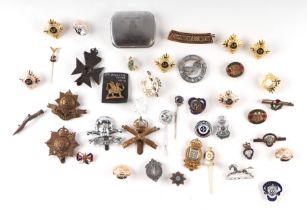 A quantity of military badges, sweetheart brooches, lapel badges and buttons