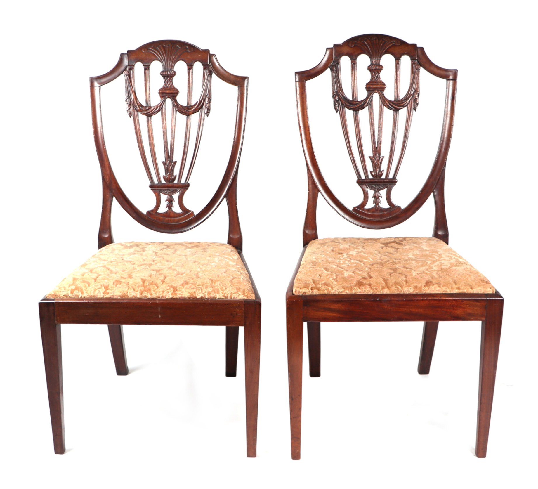 A pair of George III style mahogany dining chairs with shield shaped backs, carved and pierced