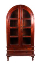 A modern continental glazed display cabinet, the twin glazed panelled doors above two drawers, on
