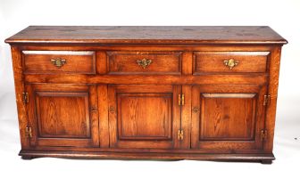 An 18th century style oak dresser base with three frieze drawers above cupboards, 167cms wide.