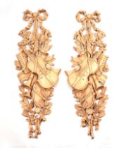 A pair of decorative composite wall plaques in the form of musical instruments, acorns and oak