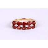 A 9ct gold dress ring set with pale red stones and diamonds, approx UK size 'O', 2.4g.