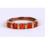 A 9ct gold dress ring set with five burnt orange stones, approx UK size 'O', 2.5g.